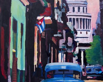 May include: A blue vintage car parked on a street in a city with a large building in the background. The building has a dome and columns. A Cuban flag is hanging from a building on the left side of the image.