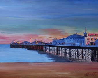 May include: An acrylic painting of Brighton Pier at sunset. The pier extends into the sea, with buildings and lights visible. The sky transitions from blue to pink and orange, reflecting on the water and beach.