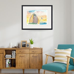 Puede incluir: Pintura acuarela de una monta&ntilde;a con un telef&eacute;rico que sube por el lado. La monta&ntilde;a est&aacute; pintada en tonos de marr&oacute;n, amarillo y verde. El cielo es azul claro con nubes rosadas.