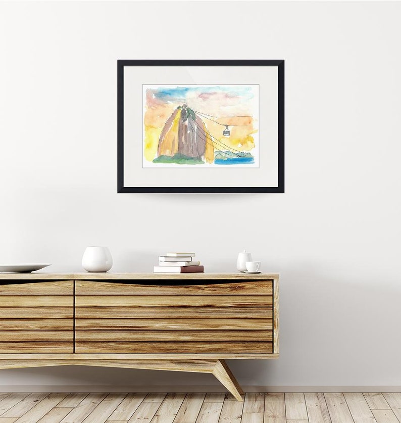 Puede incluir: Pintura acuarela de una monta&ntilde;a con un telef&eacute;rico que sube por el lado. La monta&ntilde;a est&aacute; pintada en tonos de marr&oacute;n, amarillo y verde. El cielo est&aacute; pintado en tonos de azul y rosa.