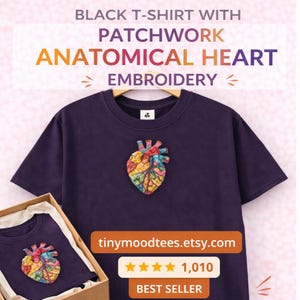 Puede incluir: Una camiseta negra con un bordado de corazón anatómico de patchwork colorido. La camiseta se muestra en una percha y en una caja. El texto de la imagen dice "BLACK T-SHIRT WITH PATCHWORK ANATOMICAL HEART EMBROIDERY".
