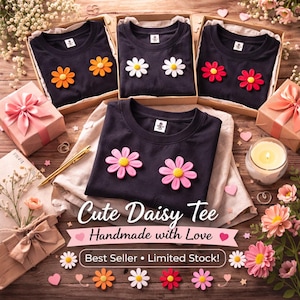 May include: Navy blue t-shirts with daisy embellishments in orange, white, pink, and red, presented in gift boxes. The image includes the text "Cute Daisy Tee Handmade with Love" and "Best Seller • Limited Stock!"