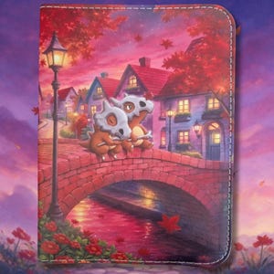 Könnte beinhalten: Ein rechteckiger Notizbuchumschlag mit einer lebendigen Illustration von zwei Cubone-Figuren, die bei Sonnenuntergang auf einer Ziegelbrücke sitzen. Die Szene zeigt eine hohe Straßenlaterne, rote Herbstbäume und Häuser in warmen Rosa- und Orangetönen.