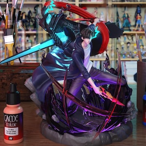 May include: A detailed figurine of a character in action, wielding a glowing blue sword and a fiery weapon. The figure is set against a backdrop of other figurines and art supplies, including paint bottles and brushes. The color palette includes shades of blue, black, red, and purple.