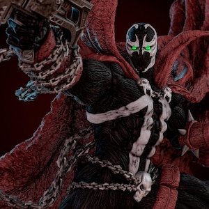 May include: A detailed action figure of Spawn, a comic book character, in a dynamic pose. The figure is predominantly black with a white skeletal design on the chest and a large red cape. It holds a large gun and is adorned with chains and a skull.