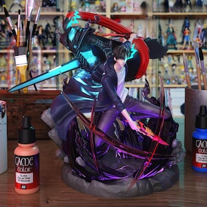 May include: A detailed figurine of a character in action, wielding a glowing blue sword and a fiery weapon. The figure is set against a backdrop of other figurines and art supplies, including paint bottles and brushes. The color palette includes blues, reds, and purples.