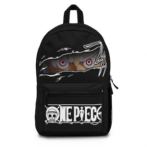 Könnte beinhalten: Ein schwarzer Rucksack mit einer Grafik von intensiven rosa Augen, die durch einen Riss-Effekt im Stoff oben hervorschauen. Die untere Vordertasche zeigt das weiße One Piece-Logo, das links ein Totenkopf-Emblem mit gekreuzten Knochen enthält.