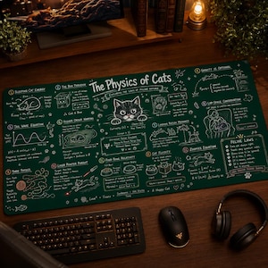 Peut inclure: Un tapis de bureau vert avec le titre "The Physics of Cats" et divers schémas scientifiques et un chat de dessin animé. Le tapis comprend des équations, des diagrammes liés aux chats et la phrase "Feline Laws". Un clavier, une souris et un casque sont également visibles.
