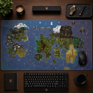 May include: A large rectangular desk mat featuring a detailed, colourful fantasy world map with various terrains, islands, and oceans. The mat is surrounded by a black mechanical keyboard, a black computer mouse, a notebook, and a candle.
