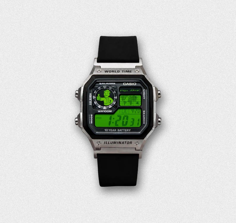 May include: A silver Casio digital watch with a black band and green digital display. The watch face features the text "WORLD TIME", "CASIO", and "ILLUMINATOR". The display shows the time as 1:20:31 and the date as TUE 4/20.