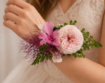 Elegant wrist corsage featuring pink preserved garden roses with refined floral accents.