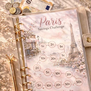 May include: A beige binder with a "Paris Savings Challenge" insert, featuring illustrations of the Eiffel Tower and a cafe. The insert has circles with euro amounts. A gold pen and euro currency are also visible.