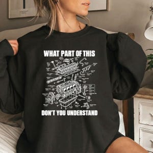 May include: A black long-sleeve sweatshirt featuring a white technical diagram of an engine with various labeled parts. The text at the top reads WHAT PART OF THIS and the text at the bottom reads DON'T YOU UNDERSTAND in a bold white font.