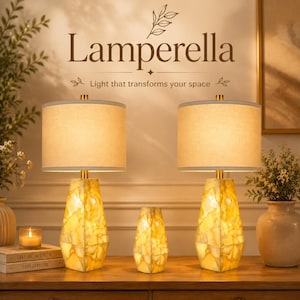 May include: Two table lamps with cylindrical beige fabric shades and faceted, translucent yellow stone bases, accompanied by a smaller matching stone accent piece. The text Lamperella and Light that transforms your space is visible above.