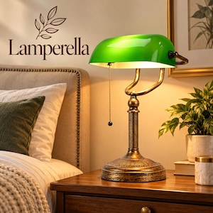 May include: A banker lamp with a vibrant green glass shade and a metallic bronze-toned base. The lamp features a pull chain switch, a curved adjustable arm, and a fluted column stand. The brand name Lamperella is printed above the lamp.