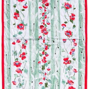 May include: A floral table runner with a white background, green vertical stripes, and red poppy flower designs. The runner has a red border and a quilted pattern. A decorative piece for a dining table.