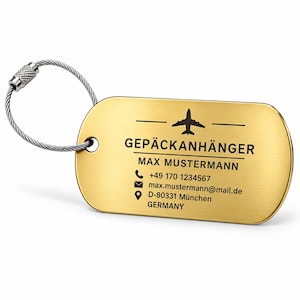 Peut inclure: Une étiquette de bagage rectangulaire dorée aux coins arrondis, avec une icône d'avion noire et le texte GEPÄCKANHÄNGER, MAX MUSTERMANN, un numéro de téléphone, une adresse e-mail et une adresse à Munich, Allemagne, fixée à un câble métallique.