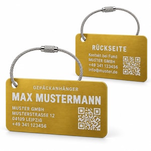 May include: Two rectangular gold-colored metal luggage tags with brushed finishes and silver wire loops. The front tag displays the text GEPÄCKANHÄNGER, MAX MUSTERMANN, MUSTER GMBH, MUSTERSTRASSE 12, 04109 LEIPZIG, +49 341 123456 and a QR code.