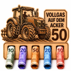 Könnte beinhalten: Ein lasergeschnittenes Holzdisplay mit einer Traktor-Illustration, dem Text "VOLLGAS AUF DEM ACKER 50" und fünf runden Schlitzen, die gerollte Euro-Banknoten im Wert von 10, 20, 50, 20 und 10 enthalten, in einer natürlichen hellen Holzoptik.