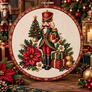 Può includere: Un telaio da ricamo circolare contenente un disegno a punto croce di uno schiaccianoci in uniforme verde e rossa. La figura tiene in mano un piccolo albero di Natale e un regalo, circondata da stelle di Natale rosse, pacchetti e decorazioni dorate.