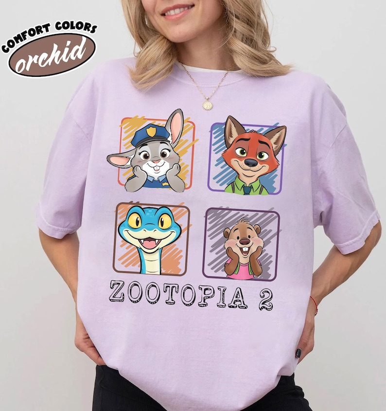 May include: A lilac t-shirt with characters from Zootopia 2. The shirt displays four square graphics with cartoon images of a rabbit, fox, snake, and beaver. The text "ZOOTOPIA 2" is printed below the graphics. The shirt also has the text "COMFORT COLORS orchid".