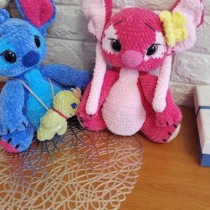 May include: A white ceramic mug with a black handle and the text "But First, Coffee" in a bold, black font. The mug is set against a blurred background, suggesting a cozy setting.