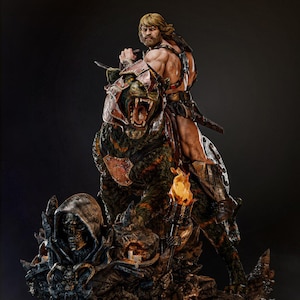 以下が含まれることがあります： 大きな装甲の猫のような生き物にまたがる、筋肉質な人物の精巧な像。その人物は剣を持ち、長い金髪です。猫は口を開けて鋭い歯を見せています。台座には骸骨とろうそくが描かれています。