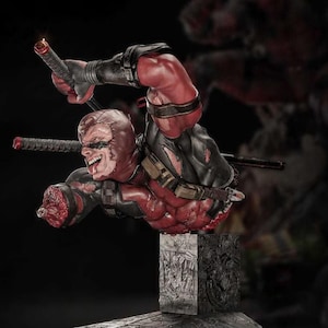 May include: A detailed statue of Deadpool in a dynamic pose, clad in a red and black suit. The figure is holding two katanas and has a menacing expression. The base is a detailed, engraved block.