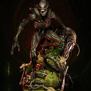 Könnte beinhalten: Detaillierte Statue einer Alien-Kreatur, mit bedrohlicher Pose und freiliegenden Zähnen. Die Figur ist überwiegend dunkelgrün und silberfarben und steht auf einem Sockel mit Alien-Eiern und organischen Elementen. Der Hintergrund ist dunkel mit roten Akzenten.