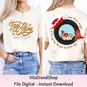 May include: A cream-colored t-shirt featuring a front graphic with rope-style text reading 'it's a Toy Story Baby, just say yes' and a back graphic showing a tire frame, a red cowboy hat, a red boot, and characters with the text 'Love has ways of bringing things back to life'.