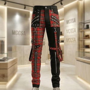 May include: Black and red plaid pants with multiple zippers and straps. The pants have a unique design, with one leg featuring a red plaid pattern and the other leg in solid black. The pants have silver hardware and a button closure.