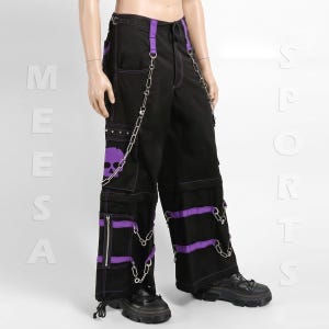 Puede incluir: Pantalones cargo negros con detalles morados, incluyendo correas, costuras y un diseño de calavera. Cadenas plateadas cuelgan de los bolsillos y la cintura. Los pantalones tienen múltiples bolsillos y cremalleras, y se usan con botas negras.
