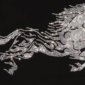 May include: A decorative iron-on transfer featuring a galloping horse silhouette composed of numerous clear, faceted rhinestones. The design is set against a solid black background, creating a high-contrast, sparkling effect with light reflecting off the stones.