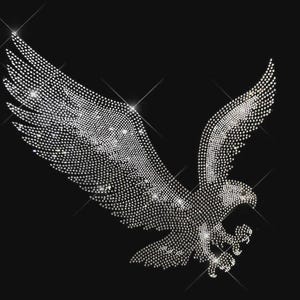 May include: A graphic design of a soaring eagle rendered in clear, reflective rhinestones against a solid black background. The eagle is depicted in a side profile with wings fully extended, creating a sparkling, high-contrast visual effect.