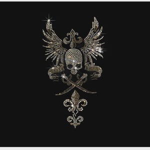 May include: A rhinestone transfer design on a black background featuring a central skull topped with a fleur-de-lis, flanked by two feathered wings, and positioned above two crossed swords with a decorative fleur-de-lis emblem at the base.