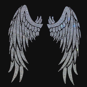 Puede incluir: Un par de alas de ángel simétricas hechas de pedrería transparente y reflectante sobre un fondo negro sólido. El diseño presenta patrones de plumas detallados creados por la disposición de cristales individuales, formando una gran aplicación decorativa.