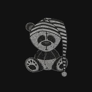 May include: A rhinestone transfer design featuring a teddy bear wearing a striped nightcap. The bear is constructed from small, reflective white crystals set against a solid black background, creating a clear, sparkling silhouette of the figure.