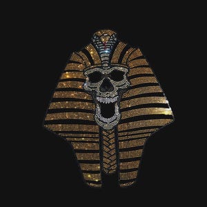 May include: A rhinestone transfer patch featuring a skull wearing a pharaonic nemes headdress. The design is composed of gold and clear crystals arranged in horizontal stripes, forming the iconic shape of an ancient Egyptian burial mask.