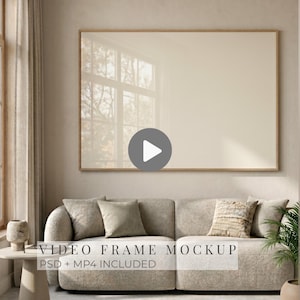 Puede incluir: Una maqueta enmarcada, rectangular y grande, con una paleta de colores neutros, cuelga sobre un sofá con cojines. El marco tiene un acabado de madera clara. El texto "VIDEO FRAME MOCKUP" es visible en la parte inferior de la imagen.