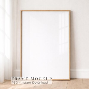 May include: A vertical rectangular picture frame with a light-toned wooden border and a blank white center. The frame is positioned upright, showcasing a clean, minimalist design suitable for displaying artwork, photographs, or prints in a home.