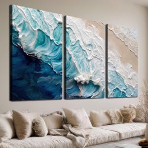 May include: A three-panel wall art set featuring an abstract ocean wave design with thick, textured impasto paint strokes in shades of deep navy blue, turquoise, light blue, and white, depicting crashing waves meeting a sandy beige shoreline.