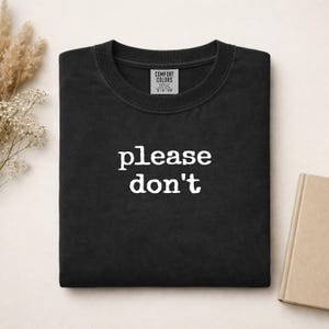 Black Comfort Colors t-shirt with "please don't" printed in white text.