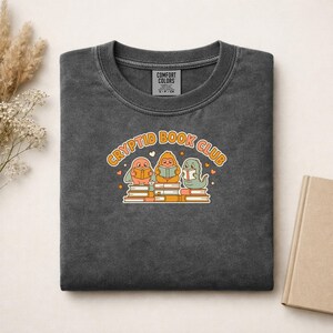 Camiseta del club de lectura de criaturas críptidas Tiny Bookworms, Mothman, Bigfoot y Nessie leyendo juntos, Comfort Colors