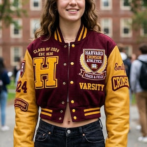 Könnte beinhalten: Eine weinrote und goldene Varsity-Jacke mit dem Text "CLASS OF 2024" und "HARVARD CRIMSON ATHLETICS". Die Jacke hat ein großes "H" auf der Vorderseite und "CRIMS" auf dem Ärmel. Die Jacke wird von einer Person getragen.