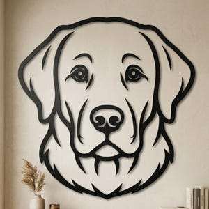 May include: Black metal wall art of a Labrador Retriever dog's head. The design is minimalist, with clean lines and detailed features. The artwork is mounted on a neutral wall, suitable for home decor. The dog's features are clearly defined.