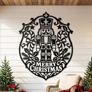 May include: A black laser-cut metal wall sign featuring a nutcracker figure centered within an ornate frame, flanked by candy canes and holly leaves, with the text Merry Christmas displayed in bold lettering at the bottom.