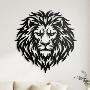 May include: A black wall art piece featuring a stylised lion head with a detailed, flowing mane. The design is composed of sharp, flame-like shapes that form the facial features and thick hair of the lion, creating a bold, symmetrical silhouette.