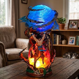 Könnte beinhalten: Detaillierte Figur einer Figur aus Dragon Ball Z. Die Figur hält eine große blaue Energiesphäre hoch. Die Basis ist feurig orange und rot, mit einem grünen Drachen darum gewickelt. Die Figur wird von Innenlichtern beleuchtet.