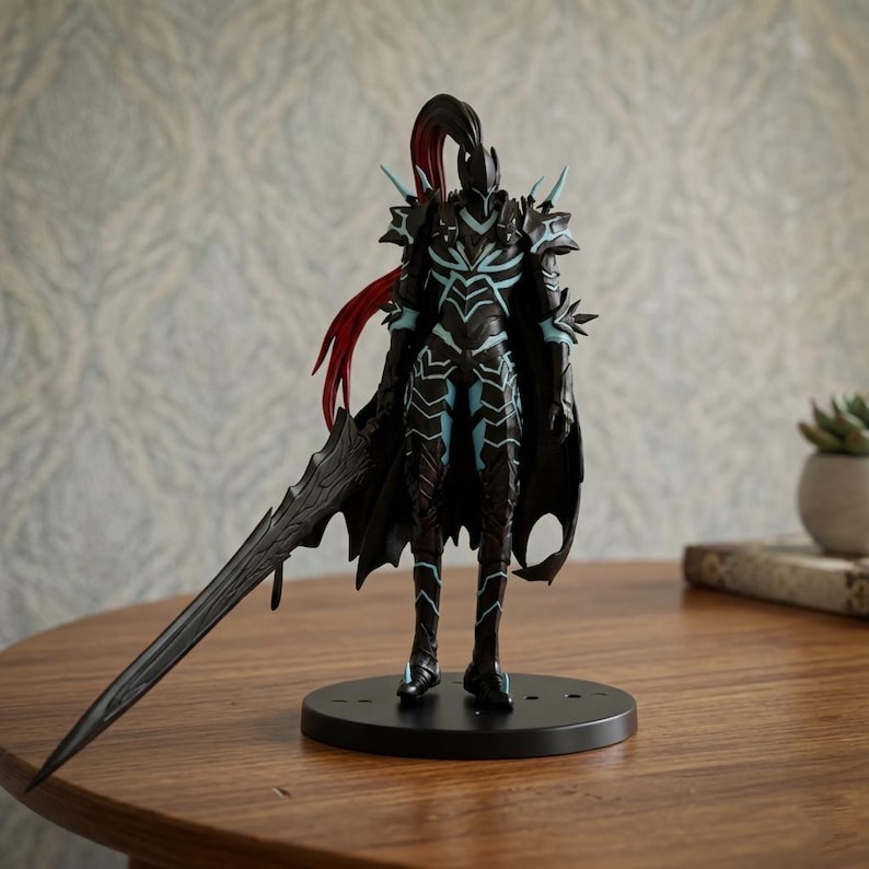 May include: A detailed figurine of a warrior in dark armor with teal accents and a long, black sword. The figure has a black cape and red hair. It stands on a black circular base, showcasing intricate design and craftsmanship.
