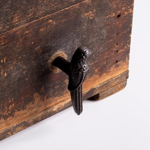 Könnte beinhalten: Eine weiße Keramik-Tasse mit schwarzem Henkel und dem Text "But First, Coffee" in schwarzer, handschriftlicher Schrift. Die Tasse steht auf einer weißen Oberfläche.